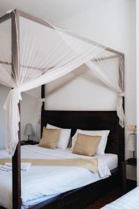 プノンペンにあるSuite Home Boutique Hotelのベッドルーム(天蓋付きベッド1台付)のベッド2台
