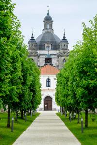 Une grande église avec des arbres devant elle dans l'établissement Monte Pacis, à Kaunas