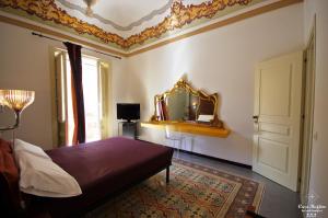 a bedroom with a bed and a mirror on the wall at B&B Casa Ruffino in Balestrate