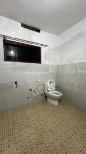 a bathroom with a toilet and a window at Alpine Homes Kanthalloor in Kanthalloor