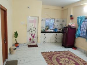 a living room with a refrigerator and a rug at Ghosh homestay 8 in kolkata
