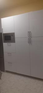 a kitchen with white cabinets and a microwave at BASAURI, céntrico, metro in Basauri
