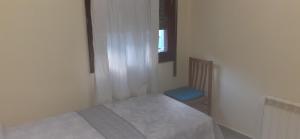 a small bedroom with a bed and a window at BASAURI, céntrico, metro in Basauri