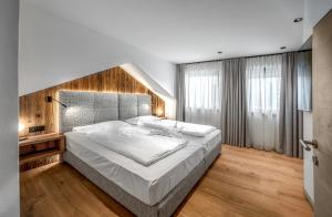 a bedroom with a large bed with a wooden headboard at Villa Pana in Santa Cristina Gherdëina