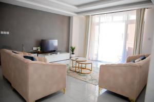 a living room with two chairs and a television at Luxury 3br Ensuite Apt in Prestigious Nyali in Mombasa