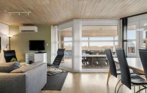 a living room with a couch and a table with chairs at Four-Bedroom Holiday Home In Hvide Sande in Hvide Sande