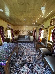 a living room with a couch and a table and chairs at House boat house of common in Sudarbal
