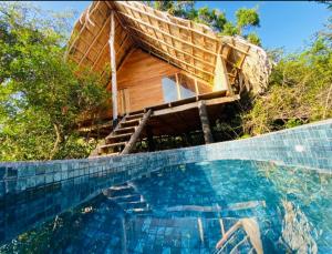 a house with a swimming pool in front of it at Mamba Yala in Tissamaharama