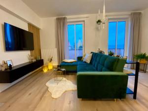 a living room with a blue couch and a tv at Cosy-Chic Apartment in Eisenach