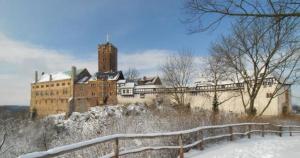 a large castle on top of a snow covered hill at Cosy-Chic Apartment in Eisenach