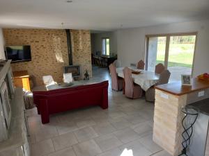 a living room with a table and a dining room at Location 24h du Mans in Parigné-lʼÉvêque