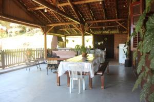a dining room with a table and chairs on a patio at Sítio Rota 77 in Canelinha