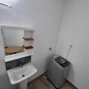 Un baño con lavabo, inodoro y espejo. en Skylux service apartment, en Ernakulam 5 fotos más