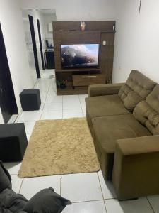 a living room with a couch and a flat screen tv at Alugo casa festival de inverno in Garanhuns