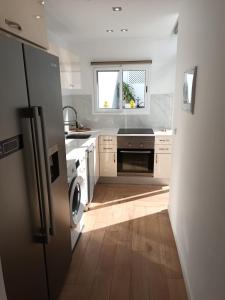 a kitchen with a refrigerator and a window in it at Agréable bungalow avec grande terrasse et piscine in Sonnenland
