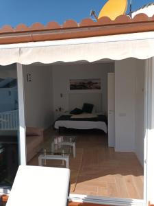 a view of a bedroom with a bed and an umbrella at Agréable bungalow avec grande terrasse et piscine in Sonnenland