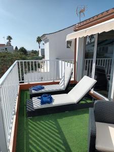 a deck with two lounge chairs on a balcony at Agréable bungalow avec grande terrasse et piscine in Sonnenland +24 photos