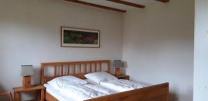 a bed with white sheets and pillows in a bedroom at 160 qm große Ferienwohnung für 5 Personen nahe Stettiner Haff in Bugewitz