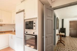 a kitchen with a refrigerator and a microwave at Casa Vacacional el Xuncu in Posada de Llanes