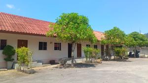 a building with a red roof and trees in front of it at Krabi Hotel Agency in Krabi town
