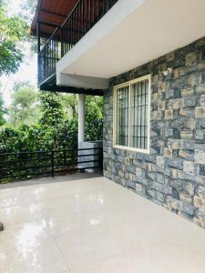 a house with a stone wall and a window at GT COFFEE ESTATE STAY coorg in Madikeri