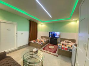 a room with two beds and a flat screen tv at Farmhouse One Bedroom Attached Bathroom in Al Rahba