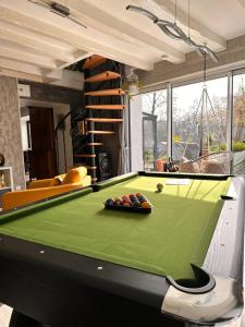 a pool table in a living room with a billiard at Villa du Beau Port in Cenon-sur-Vienne