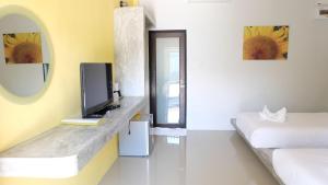 Habitación con TV, cama y espejo. en Lullaby Boutique Resort, en Thap Sakae