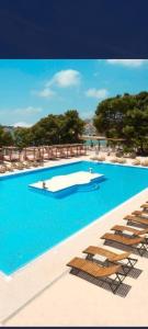 una piscina con sedie a sdraio e acqua blu di Villa Petra a Vodice