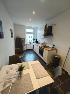 a kitchen and dining room with a table and chairs at Neu saniertes Apartment in Magdeburg in Magdeburg +12 photos