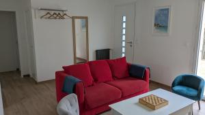 a living room with a red couch and a table at Le gîte "Guiste" in Cléder