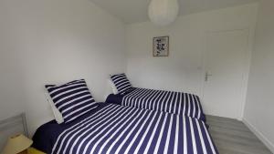 two beds sitting next to each other in a room at Le gîte "Guiste" in Cléder