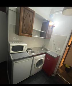 a small kitchen with a stove and a microwave at Studio Stade de France RER B in Aubervilliers