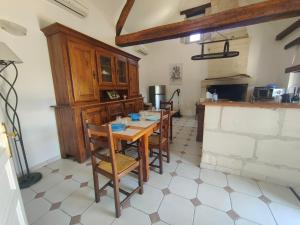 una cucina con un tavolo e sedie in una stanza di Les gîtes du Zoo,2 logements 10min du zoo piscine partagée juin-octobre & spa partagée avril-octobre ,calme & reposant a Châteauvieux