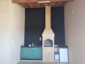 a kitchen with a brick fireplace in a room at Sobrado linda vista in São Pedro da Aldeia +2 photos