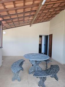 a table and two benches in a room at Sobrado linda vista in São Pedro da Aldeia
