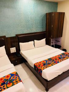 a bedroom with two beds and a blue wall at Hotel Garden Palace in Mumbai +24 photos