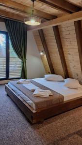 a large bed in a room with a wooden ceiling at Cabana Evia Porumbacu de Sus in Porumbacu de Sus