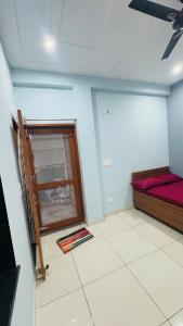a room with a bed and a glass door at Diya Apartment in Rishīkesh