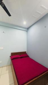 a bedroom with a red bed in a room at Diya Apartment in Rishīkesh
