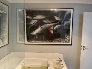 a painting of a fish on a wall above a sink at Art House Blue Room in Huonville