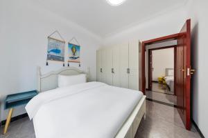 een witte slaapkamer met een groot bed en een deuropening bij 张家界博亭安屿设计师民宿 in Zhangjiajie