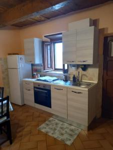 a kitchen with white cabinets and a sink and a refrigerator at Casa Vacanze da Zia Zarina in Cerdomare