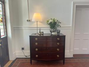a dresser with a lamp on top of it at The Alma House 1900 in Cape Town