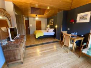 a bedroom with a bed and a desk with a television at Auberge de L'an 1600 in Bouillon