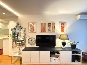 Una sala de estar con un televisor en la pared. en Apartment Elza, en Belgrado