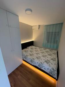a small bedroom with a bed and a window at Villa Taraxha in Mitrovica
