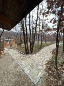 a stone walkway with a picnic table and trees at Villa Taraxha in Mitrovica