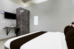 a bedroom with a bed with a black and white blanket at Hotel O Shivoham in Indirapuram