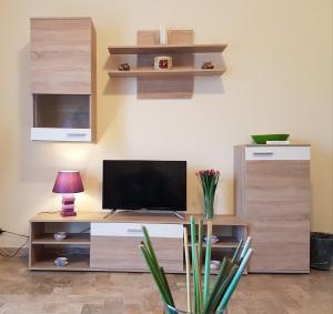 a living room with a television on a wooden entertainment center at B&B Monté in Montesilvano
